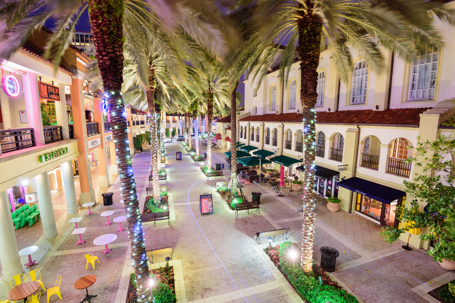 Palm trees line the mixed-use development CityPlace (now Rosemary Square) at night. Shops and restaurants fill the streets between Rosemary Avenue and Clematis Street, West Palm Beach, Florida - April 3, 2016. Editorial credit: Sean Pavone / Shutterstock.com, licensed.