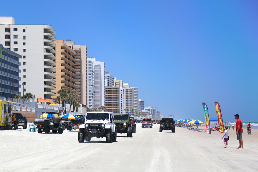 Multi-colored jeep wranglers ride on Daytona Beach. Daytona Beach, Florida - May 1 2019. Editorial credit: RudenkoStudio / Shutterstock.com, licensed.