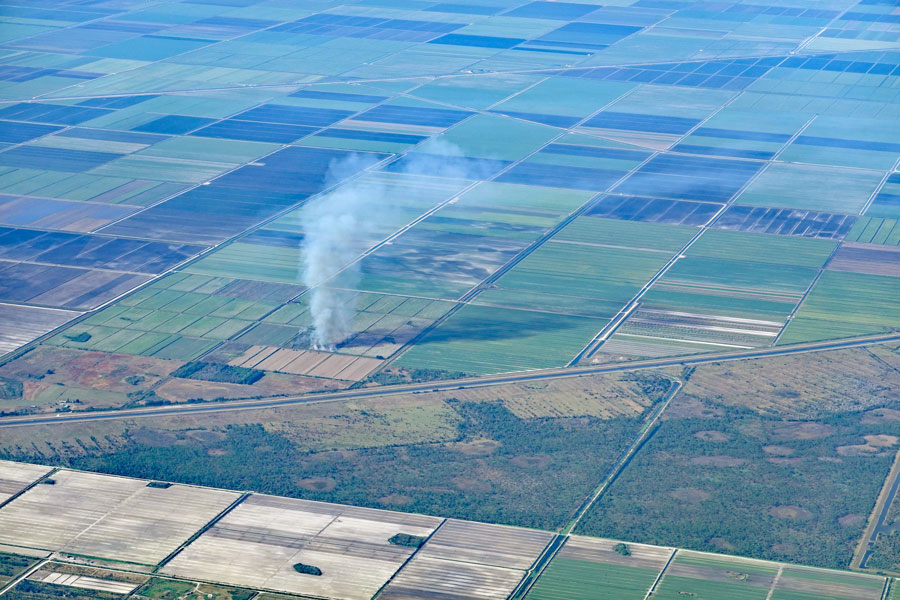 Aerial view of the sugar cane fields, burning, in South Florida, near Lake Okeechobee, Belle Glade, South Bay and Pahokee. It causes air pollution. Photo credit ShutterStock.com, licensed.