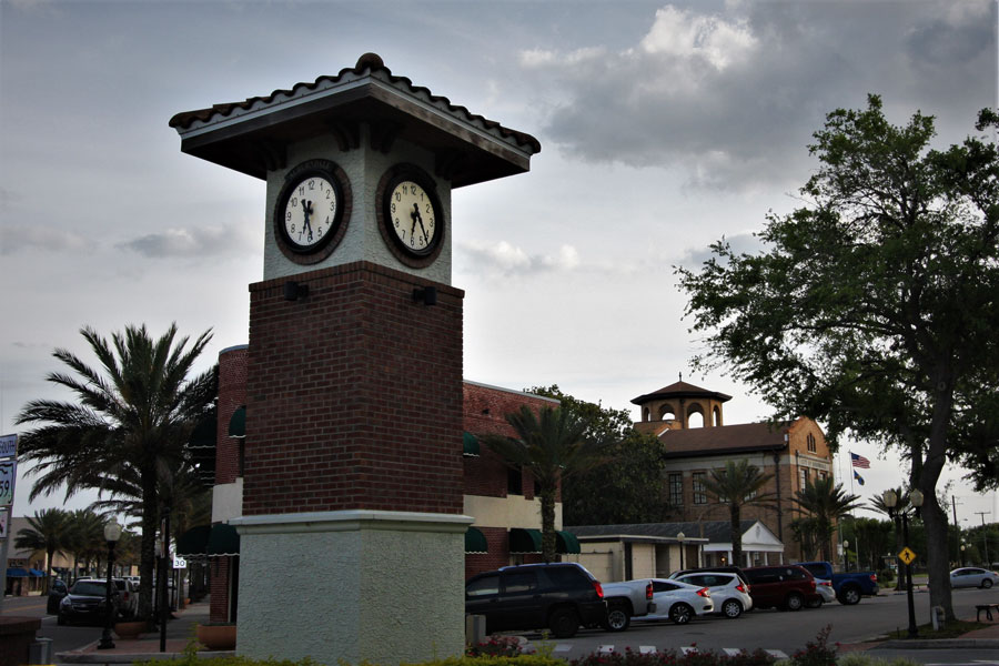 Clock tower in the city park of Auburndale, Florida, with the Flatiron Building and City Hall visible in the background.