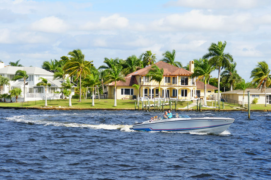 The view of a boat and waterfront home by the bay in Cape Coral, Florida on December 3, 2018. Editorial credit: Khairil Azhar Junos / Shutterstock.com, licensed.