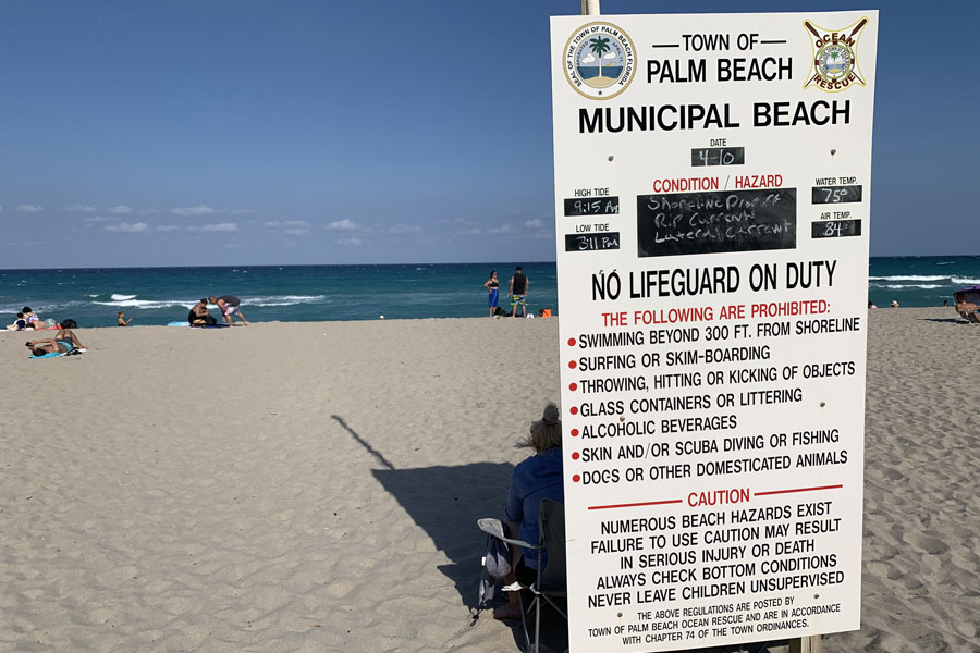 A town of Palm Beach Municipal Beach sign showing 75 degree waters and an air temperature of 84.