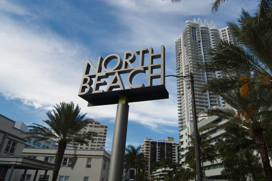 Residential buildings and a North Beach welcome sign in North Miami Beach, Florida.