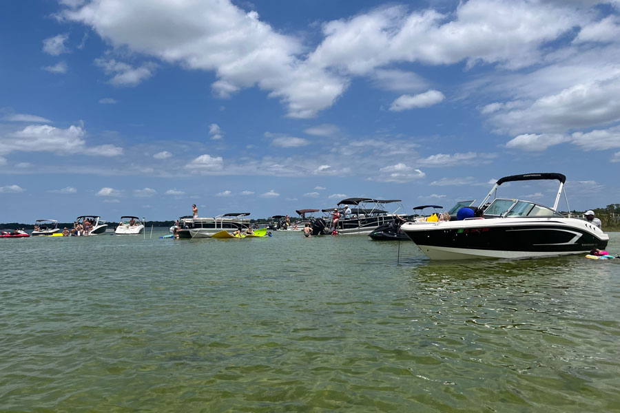 Lake Conway Sandbar Party in Orlando FL with dozens of boats on the lakewith thier occupants  relaxing. 